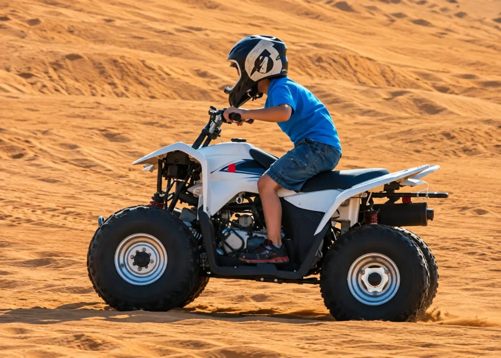 Young child wearing a safety helmet riding a small quad bike in a designated desert area.