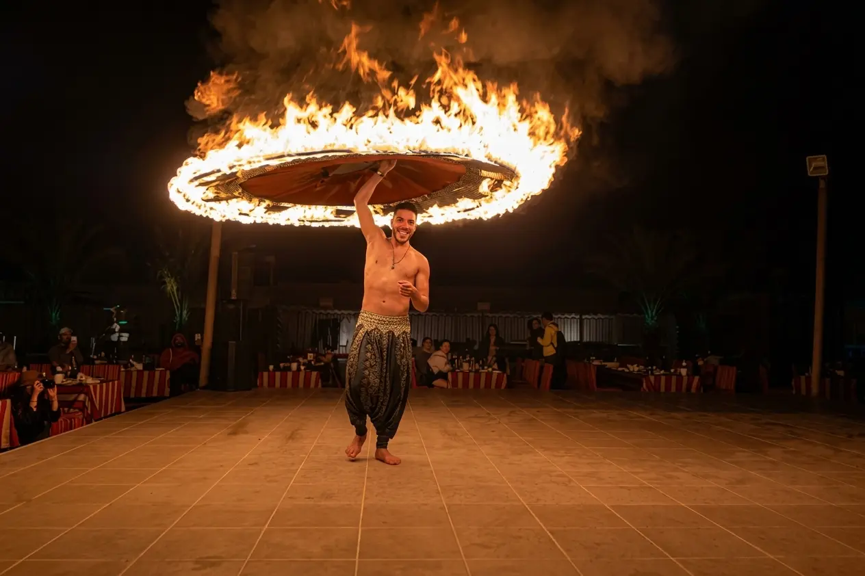 Male fire artist spinning a large flaming ring onstage at a Dubai desert safari camp